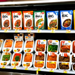 **Prompt:** A vibrant display of Korean ready-meal kits in a bustling Ankara supermarket, showcasing Bulgogi and Bibimbap options with Turkish language labels. Focus on fresh ingredients and appealing packaging.